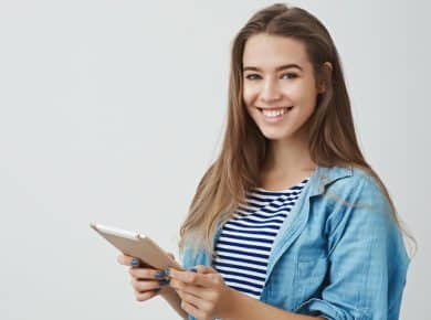 Mujer sonríe mientras observa información de factura electrónica en su tablet