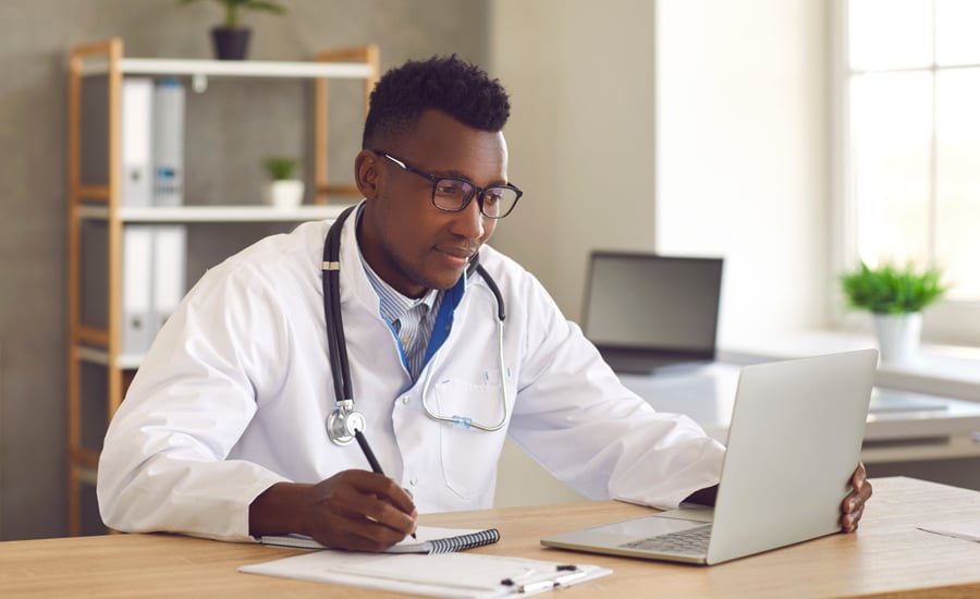 Doctor revisa su laptop en la que consulta información de facturación